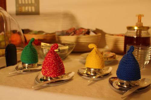 four knitted sift spoons with caps on a table at Eco Bnb & Apartments Bründlerhof in Marlengo