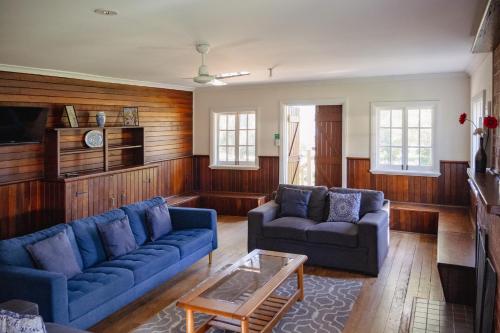- un salon avec deux canapés bleus et une table basse dans l'établissement Fairbridge Village, à Pinjarra