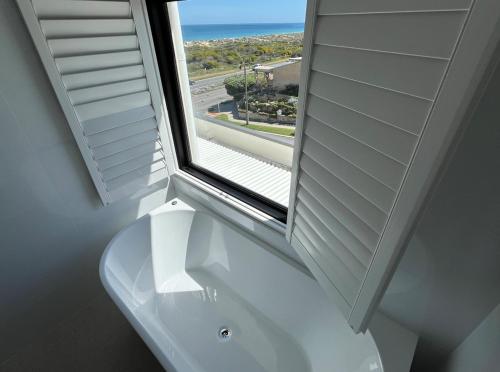 a bathroom with a window and a white sink at Beach House Perth in Perth