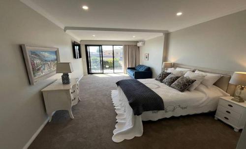 a bedroom with a large white bed and a window at Beach House Perth in Perth