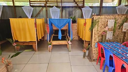 a room with a blue and yellow table and chairs at Kelly's Mountain Honey Homestay in Goroka