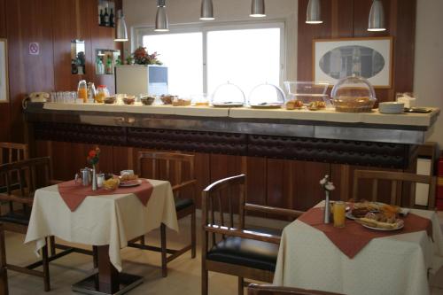 a restaurant with two tables and a bar with food at Amalia in Thessaloniki