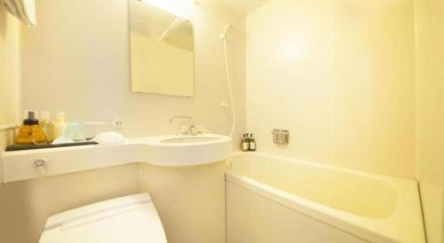 une salle de bain avec toilettes, lavabo et baignoire dans l'établissement Centurion Hotel Technoport Fukui- Artificial Radium Hot Spring, à Mikuni