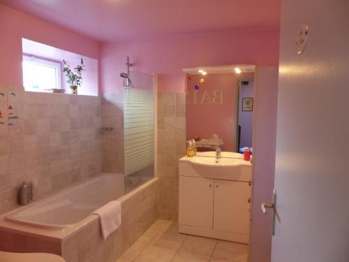y baño con bañera y lavamanos. en Chambre D'hôtes De Bellevue, en Lanvallay