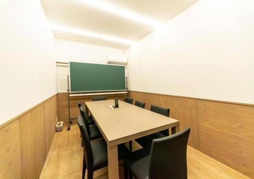 a classroom with a table and chairs and a screen at TenangTenang - Izu Oceanic Villa in Ito