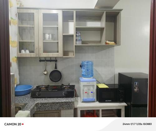 une petite cuisine avec une cuisinière et un micro-ondes dans l'établissement Prift Royal Apartments, à Meru