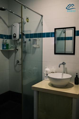 a bathroom with a sink and a glass shower at City-Center Heritage Getaway for 12 Pax in George Town