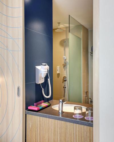 a bathroom with a sink and a mirror at ibis Styles Bogor Pajajaran in Bogor