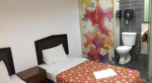 a bedroom with a bed and a toilet in a room at All Star Hotel Melaka in Melaka