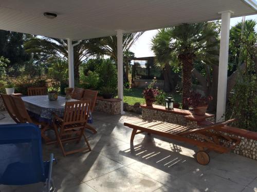 a patio with a table and chairs under an umbrella at Villa Priscilla in Cinisi