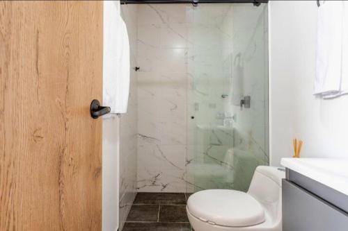 um banheiro com vaso sanitário e box de vidro em apt 3 habitaciones em Rebolo