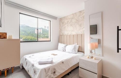 um quarto branco com uma cama grande e uma janela em apt 3 habitaciones em Rebolo