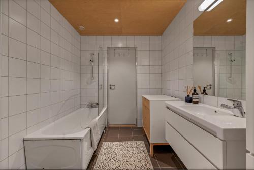 a bathroom with a tub and a sink and a bath tub at Northstay - House of Northern Lights in Tromsø
