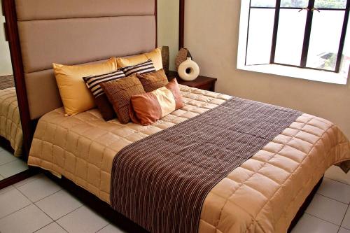 a bedroom with a large bed with many pillows at La Casarita in Manila