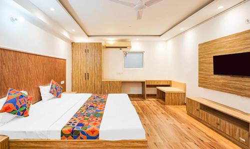 a bedroom with a large bed and a flat screen tv at Golden Sky in Noida