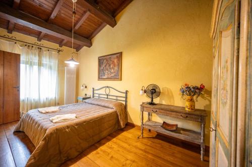 a bedroom with a bed and a table in it at Spino Fiorito Stay in Casola in Lunigiana