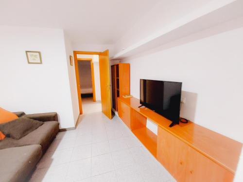 ムルシアにあるAlojamiento San Juan en Murcia Centroのリビングルーム(木製エンターテイメントセンター内のテレビ付)