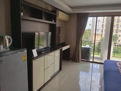 a living room with a tv and a large window at House Of Pattaya- Near Walking Street in Pattaya South