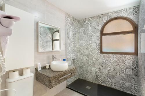 a white bathroom with a sink and a mirror at El Nido de los Ángeles in Playa del Ingles