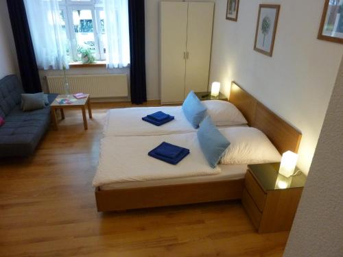 a bedroom with a bed with blue pillows on it at Lessing-Apartment in Düsseldorf