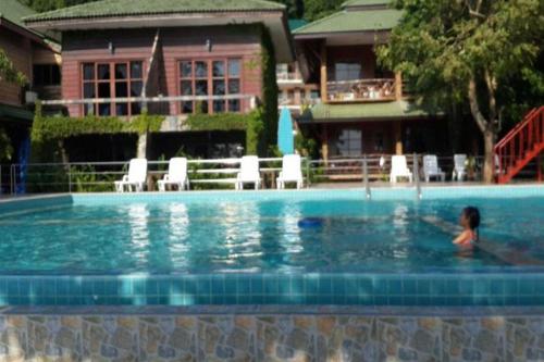 un garçon nageant dans une piscine dans une maison dans l'établissement Buffalo Bill Hotel Koh Chang, à Ko Chang