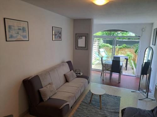 ein Wohnzimmer mit Sofa und Tisch in der Unterkunft Cap City, modeste rez-de-jardin 500m plage et du Port in Cap d'Agde