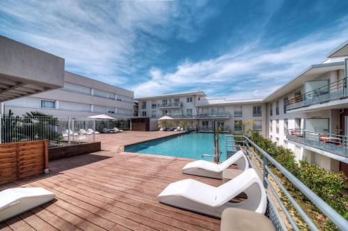 an apartment patio with a swimming pool in a building at Comfort Aparthotel Antibes Le Maestria in Antibes