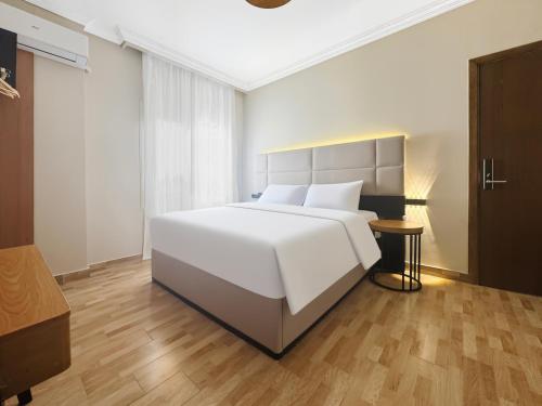 a bedroom with a large white bed and a table at 利恩之家 Maison Lienne in Cairo