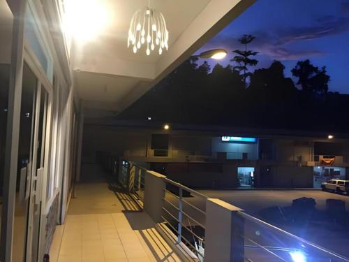 a balcony of a building at night with a chandelier at The Second Room in Ranau