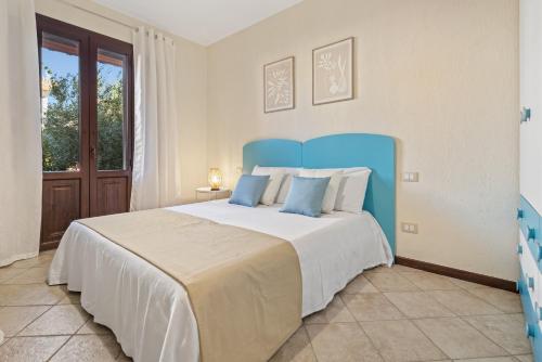 a bedroom with a large bed with a blue headboard at Casa Lisa Agorà mare e relax in Villasimius