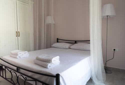 um quarto com uma cama com toalhas brancas em Elounda Sea Suites em Elounda