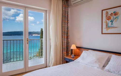 ein Schlafzimmer mit einem Bett und einem großen Fenster in der Unterkunft Orsan Hotel by Aminess in Orebić