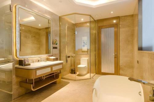 a bathroom with a sink and a toilet and a mirror at YM Gold Olives Harmony International Hotel in Shenzhen