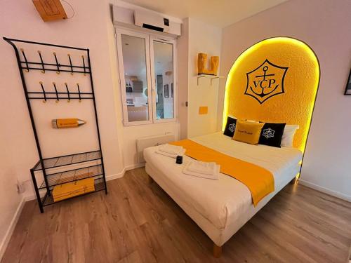 a bedroom with a bed with a yellow headboard at L'Ecrin de Clicquot, studio cosy au cœur d'Epernay in Épernay