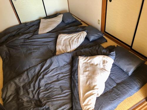 an unmade bed with two pillows in a room at Chichibu Mizuno-stay in Chichibu