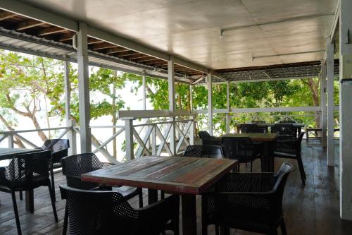 a wooden table and chairs on a patio at Mari Mari Sepanggar Lodge in Kota Kinabalu