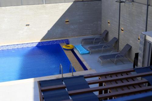 einen Blick über einen Pool mit blauen Stühlen in der Unterkunft شاليه ولا بالأحلام in Al Rama