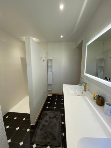 a bathroom with two sinks and a mirror at L'Armande in Meljac
