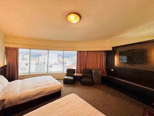 une chambre d'hôtel avec deux lits et une télévision à écran plat dans l'établissement 奇萊大飯店 Chuline Hotel, à Hualien