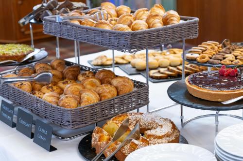 una exposición de diferentes tipos de pasteles y pasteles en Hotel Meida, en Pozza di Fassa