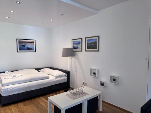 une chambre blanche avec un lit et une table dans l'établissement Apartment Nera - Zell am See, à Zell am See