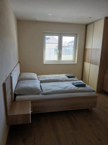 a bed in a room with a window at Apartmány ALTI in Prosiek