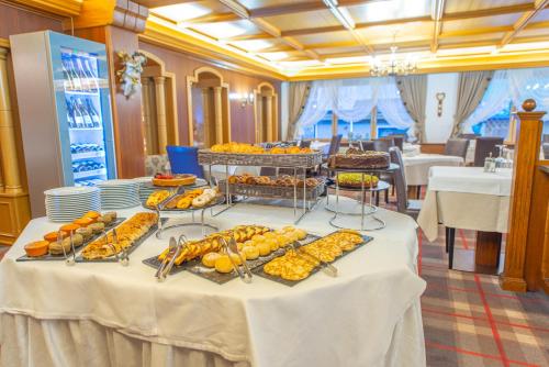 Una mesa con un buffet de comida encima en Hotel Meida, en Pozza di Fassa