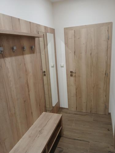 a room with two wooden doors and a wooden bench at Apartmány ALTI in Prosiek
