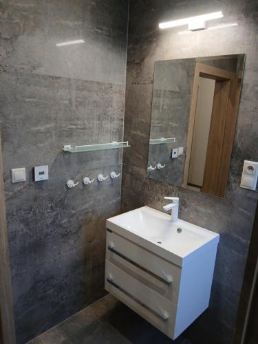 a bathroom with a sink and a mirror at Apartmány ALTI in Prosiek