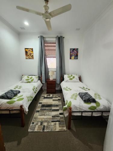 a bedroom with two beds and a window at Bottlebrush Retreat Geraldton in Geraldton