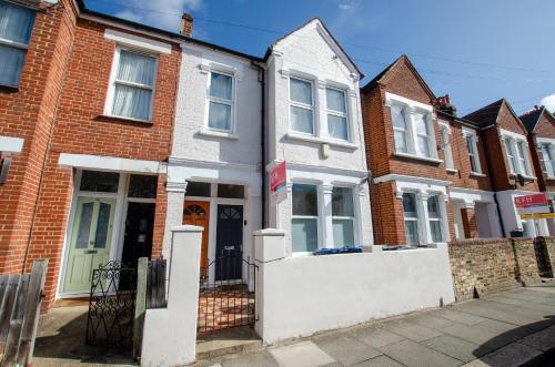 a row of brick houses on a street at Entire Modern Apartment with Garden Near Underground Station in London