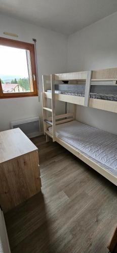 a room with two bunk beds and a window at Un coin de paradis au pied des pistes avec balcon in Métabief