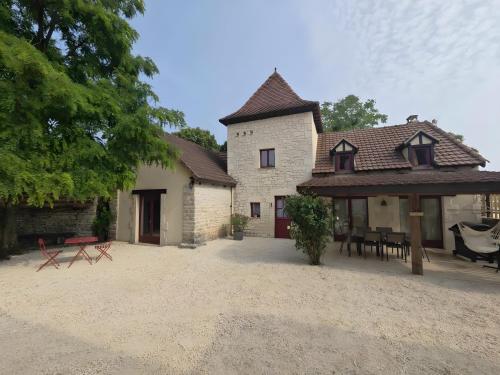 a house with a picnic table and a patio at Gite Du Mas De Palaille in Le Juge
