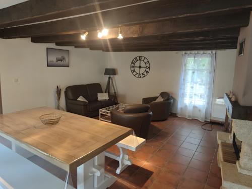 a living room with a wooden table and chairs at Gite Du Mas De Palaille in Le Juge